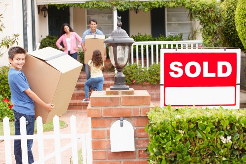 Removalists carrying household items through a residential property